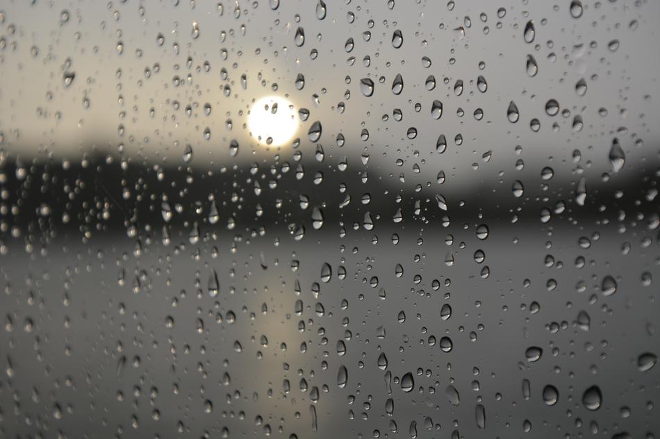 rainy evening, setting sun through Drops Of Water on Window glass