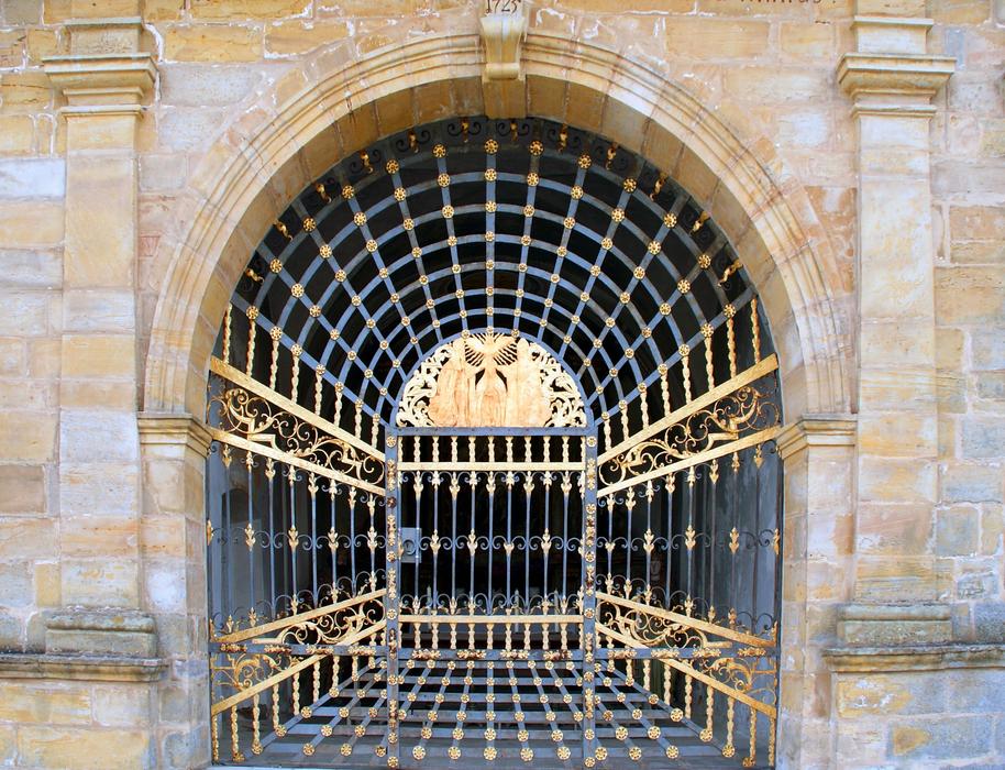 Closed gilded wrought iron gates of historical cathedral