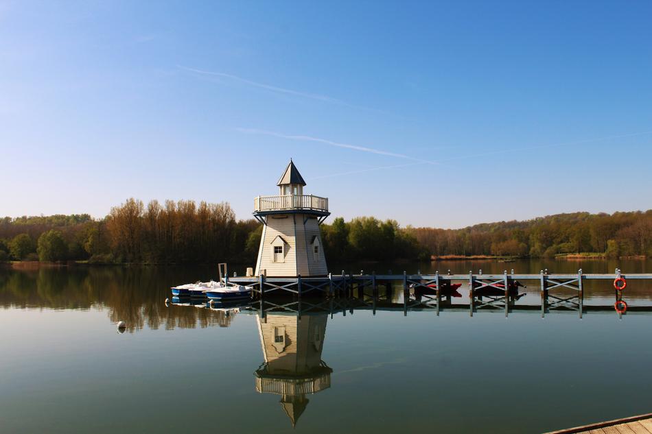 historical Lighthouse on Water near shore at fall