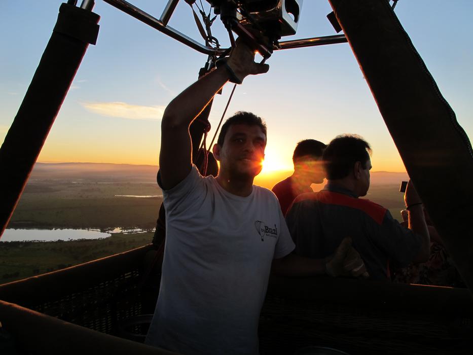 people in a hot air balloon with the sun in the background