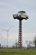 sculpture of a white car on a pole