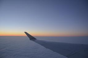 airplane wing in the sky with clouds