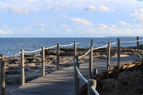 wooden bridge by the sea with stones