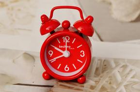 red alarm clock on the bed