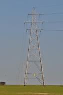 electric pylon on a field on a sunny day