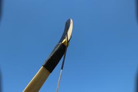 stretched wooden bow against the sky