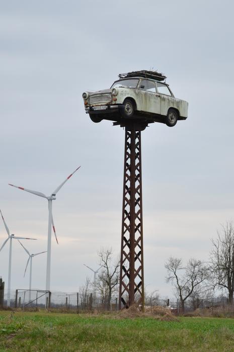 sculpture of a white car on a pole