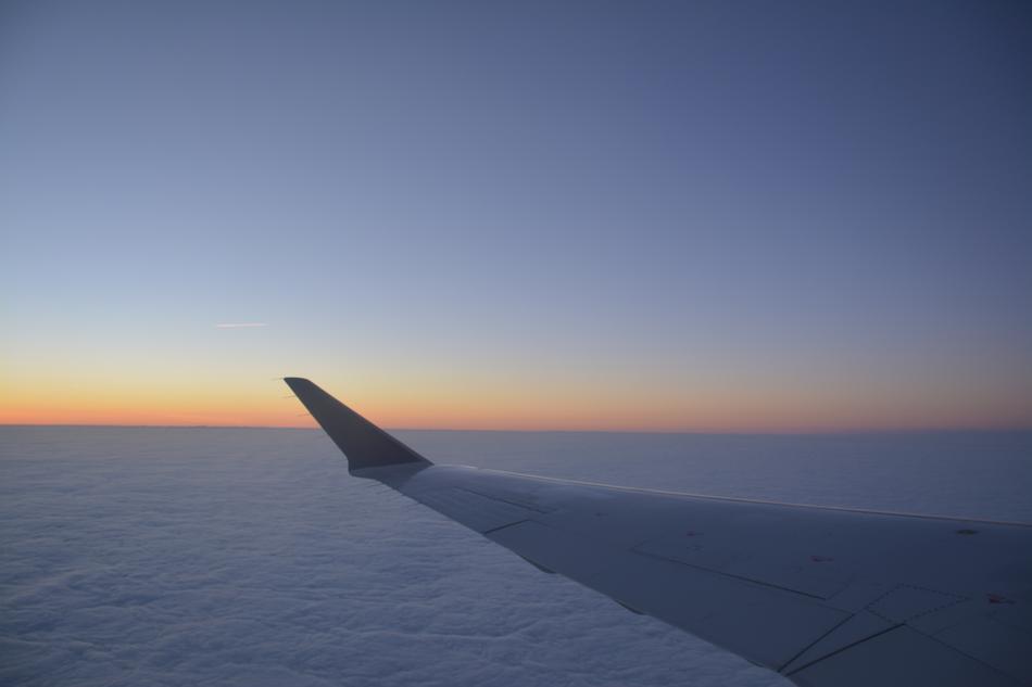 airplane wing in the sky with clouds