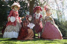 people in masquerade dresses and masks