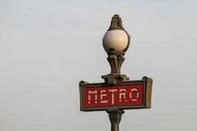 subway sign on a street lamp
