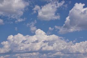 Fluffy white clouds move across the sky