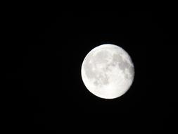 white moon in the black night sky