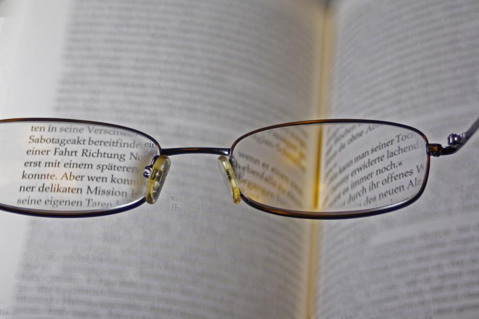 glasses aimed at the letters in the book
