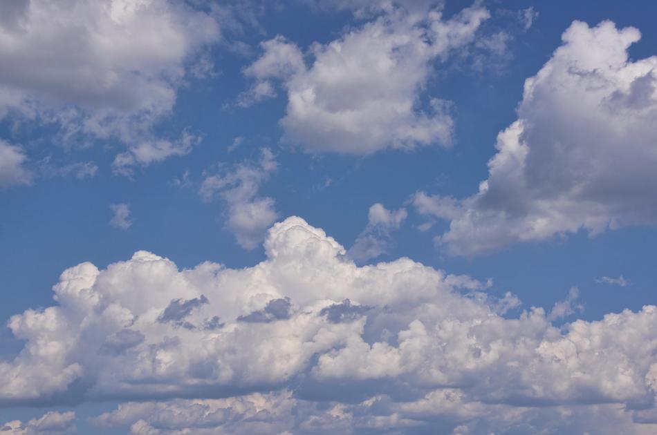 Fluffy white clouds move across the sky