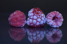 Frozen raspberries on a black background