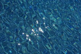 reflection of the sun in the blue water