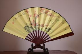 Opened fan with patterns on the table