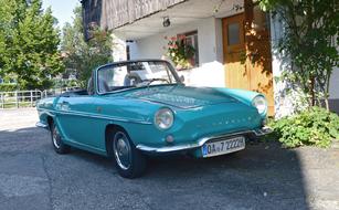 a blue car with license plates in front of the house