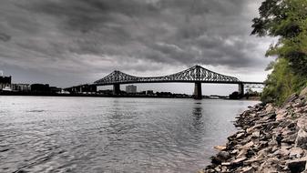 a long bridge with the sea and rocks