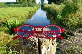 red frame glasses by the river