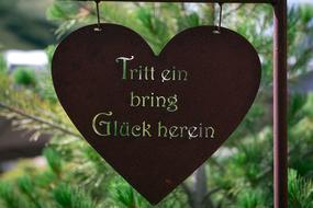iron heart shaped sign with a signature