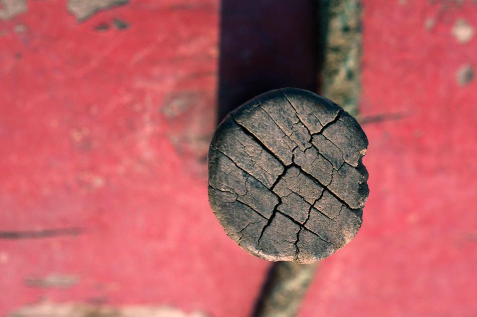wooden stake in the red wall