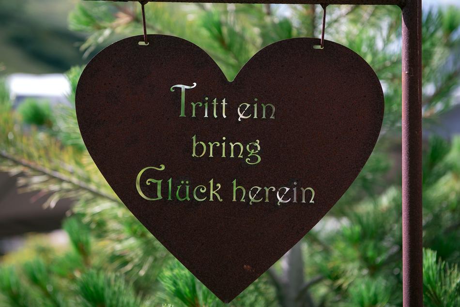 iron heart shaped sign with a signature