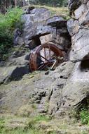 wooden waterwheel in the rocks