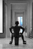sculpture of a man sitting in black stone in a museum