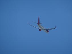 a passenger plane flying in the blue sky