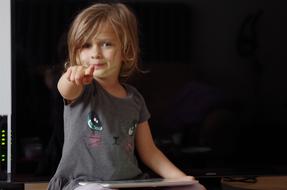 the little girl is pointing her finger