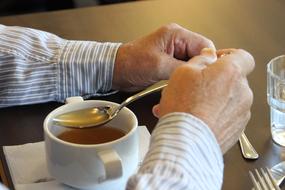 man holding spoonful of tea