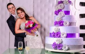 a beautiful couple with a cake and a view of the landscape