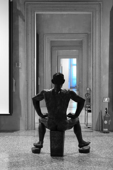 sculpture of a man sitting in black stone in a museum