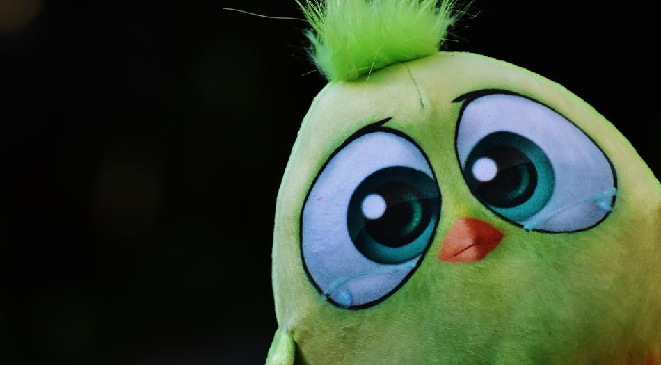 plush green bird on black background
