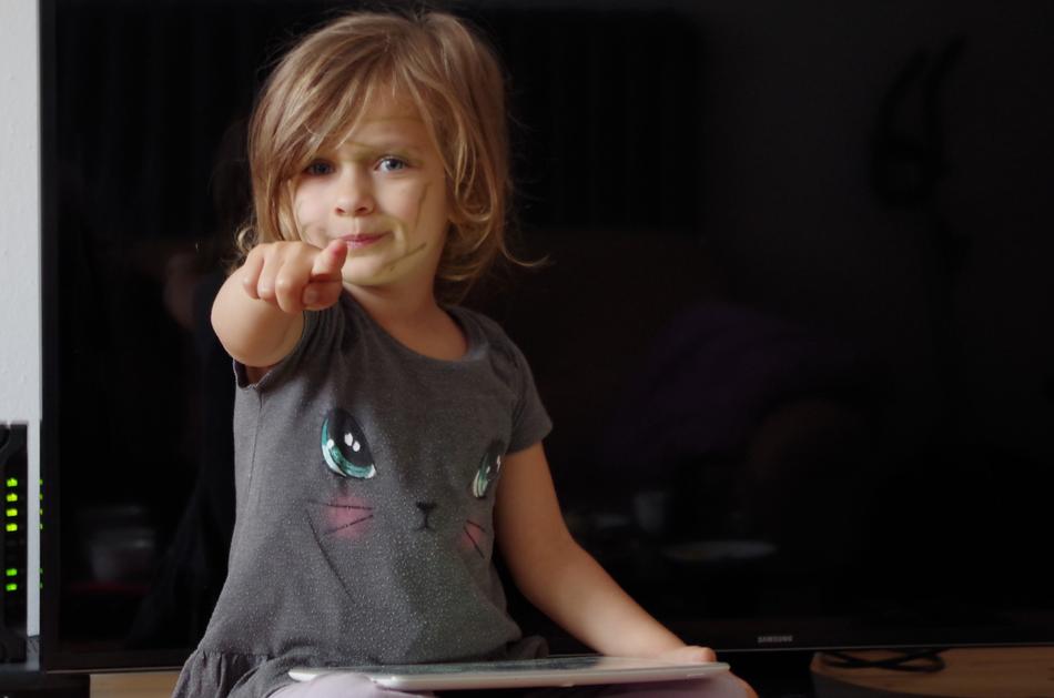 the little girl is pointing her finger