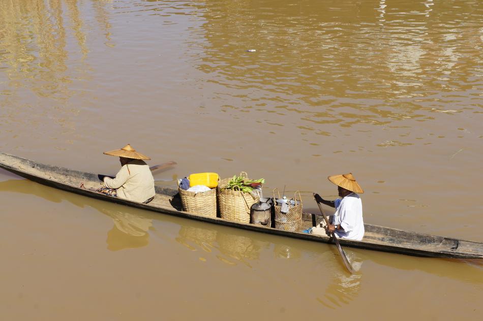 people on a long boat in a river