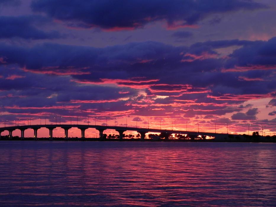 A long bridge with a sunset