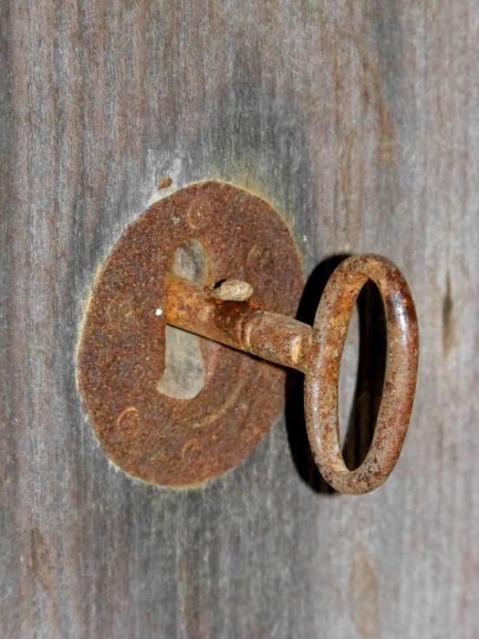 A rusty key with a lock in the door