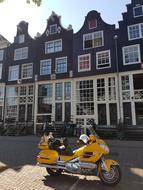 yellow motorcycle near the buildings