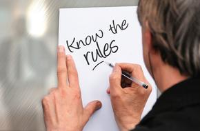 man writes on a sheet of paper