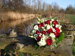 red and white wedding bouquet on the background of the river