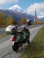 scooter standing by the road by the mountains