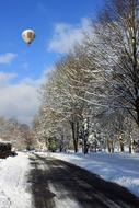 balloon flying in the sky over a winter forest