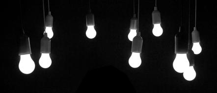 Black and white photo of the beautiful, shining light bulbs, among the darkness