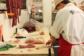 man slices meat in the kitchen