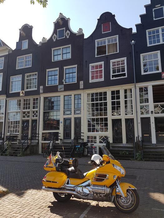 yellow motorcycle near the buildings