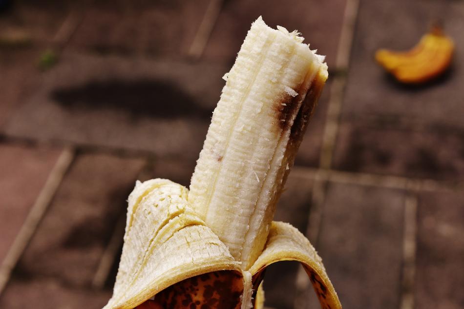 partly unpeeled Banana with brown spots