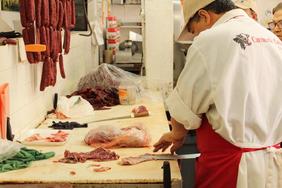 man slices meat in the kitchen