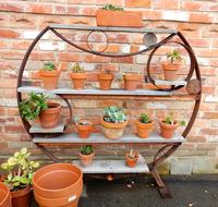 potted flowers on a decorative rack in the garden